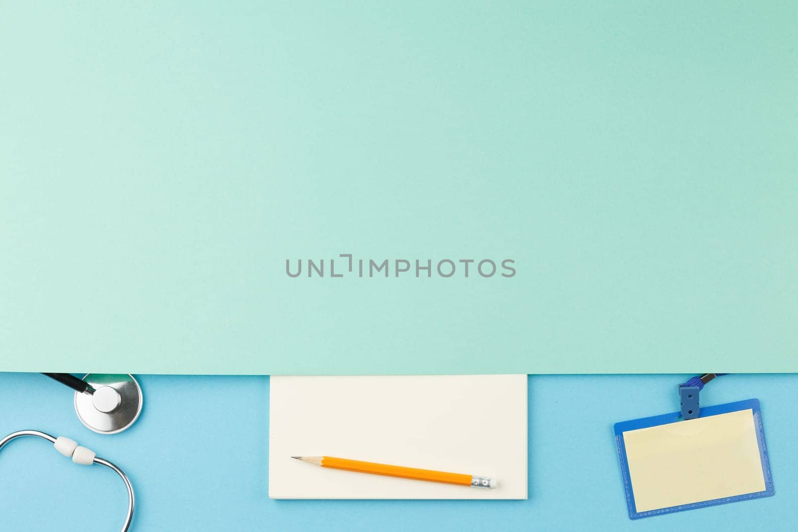 Stethoscope with badge on color isolated background top view. Blank sheet of notepad with pencil. Flat lay medical worker desktop concept. Nurse workplace with copy space.