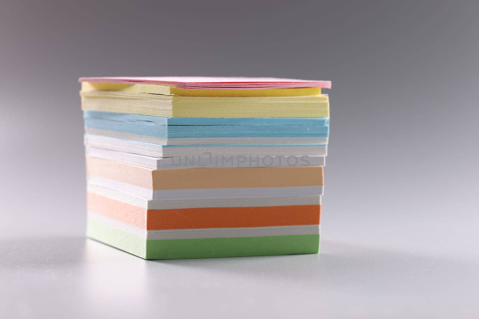 Stack of multicolored sticky notes on gray background by kuprevich