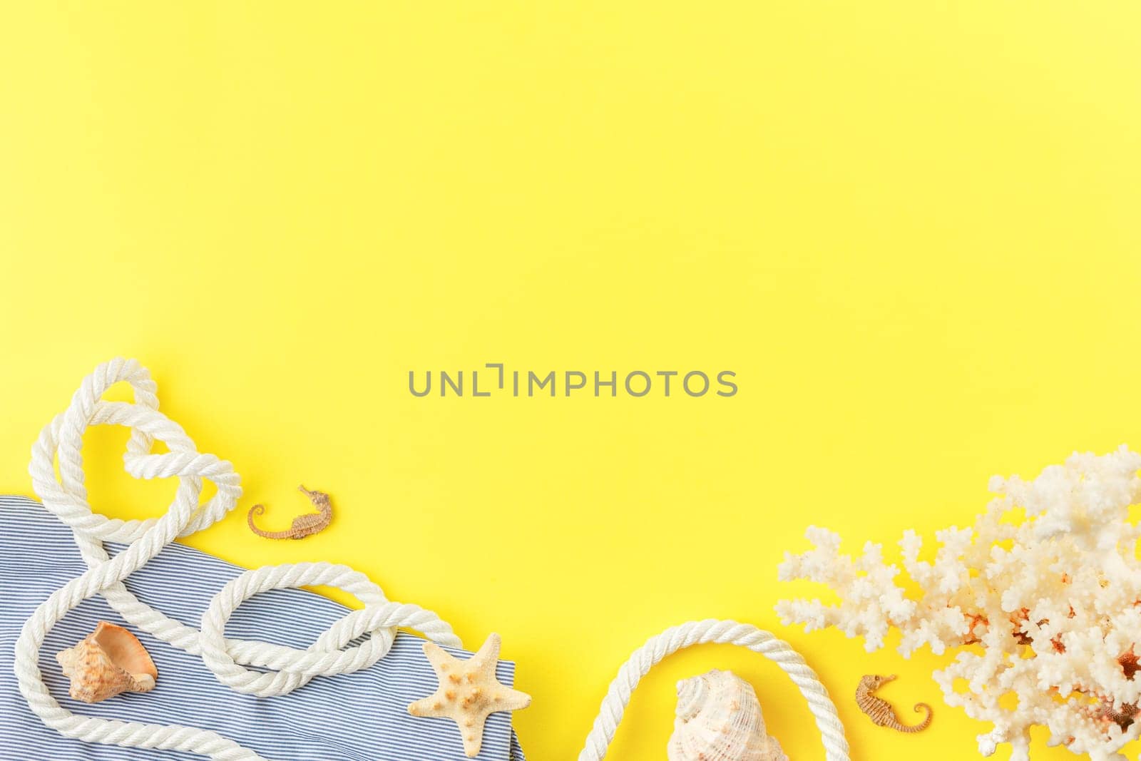 Nautical rope and striped tunic on yellow background with copy space. Flat lay. Summer vacation concept. Starfish and coral. Top view.