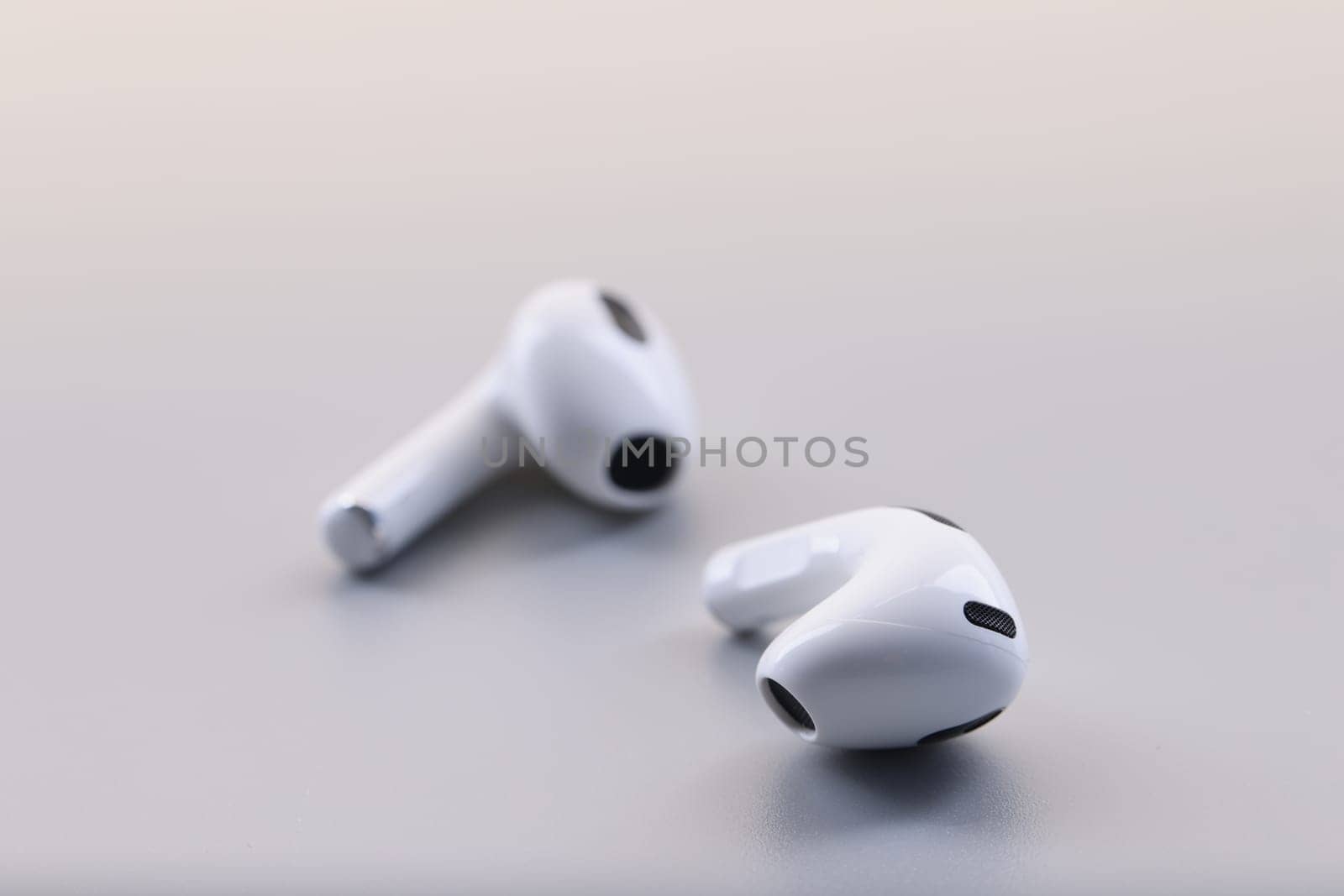 Wireless white stylish bluetooth headphones on gray background. Headset for listening to music