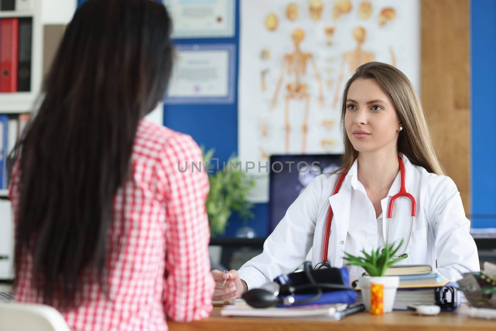 Woman is listening to general practitioner or gynecologist in clinic office by kuprevich