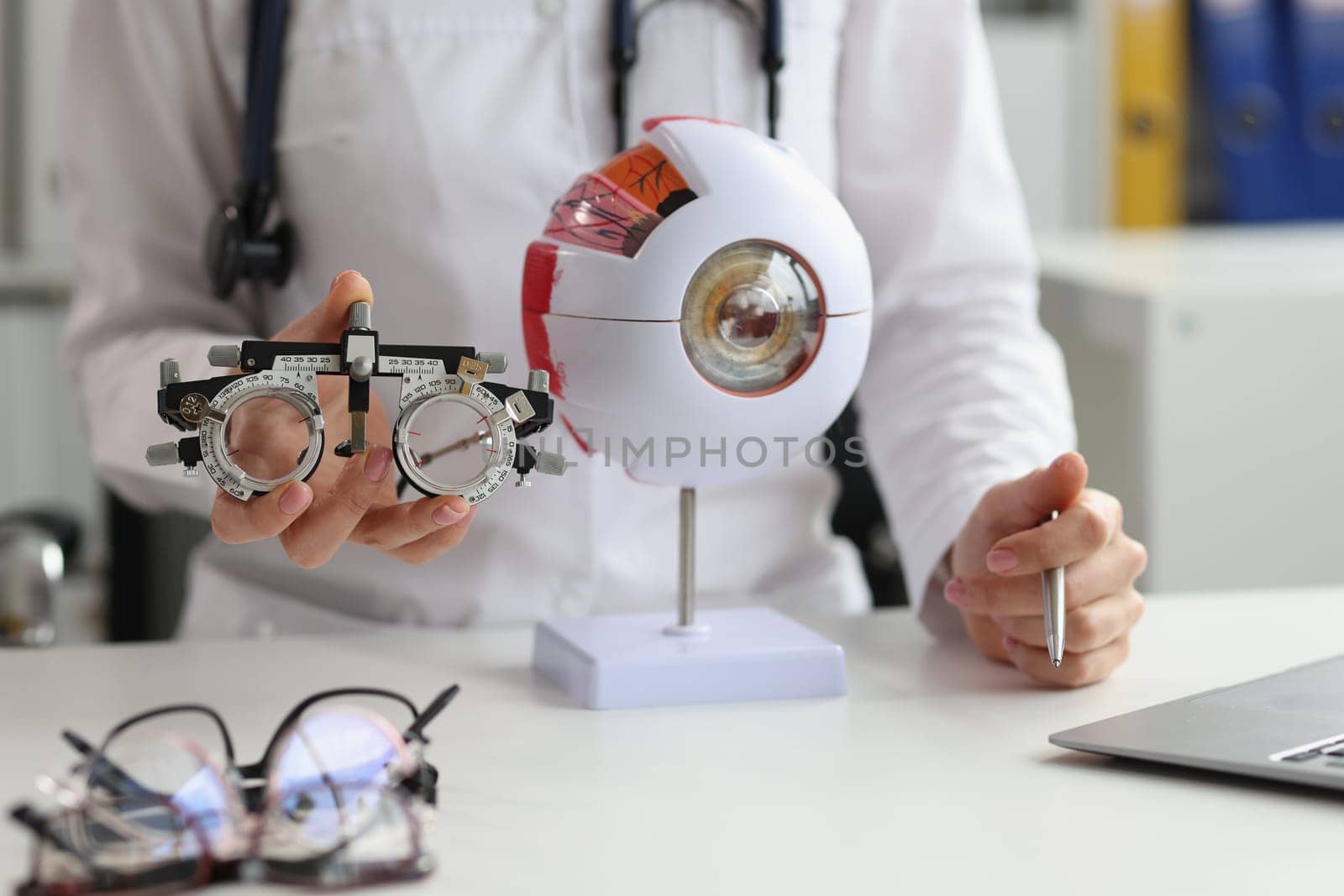 Ophthalmologist holds glasses for selection of lenses and anatomy of human eye. Health care eye anatomy structure