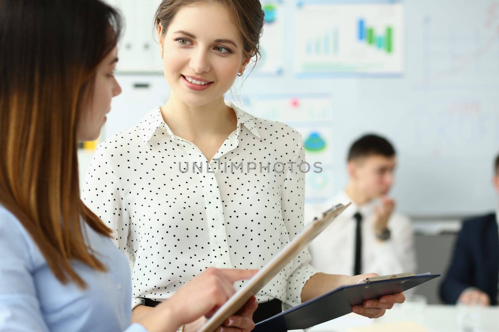 Two business women are discussing work in office by kuprevich