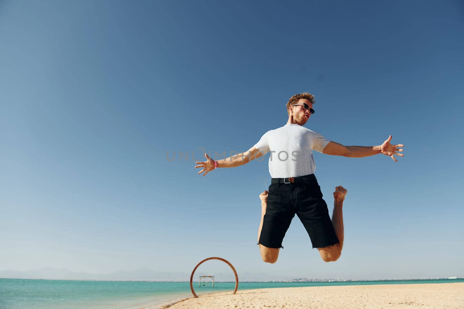 Having fun. Young european man have vacation and enjoying free time on the beach of sea.