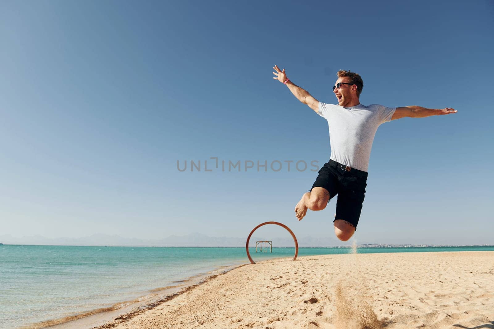 Having fun. Young european man have vacation and enjoying free time on the beach of sea.