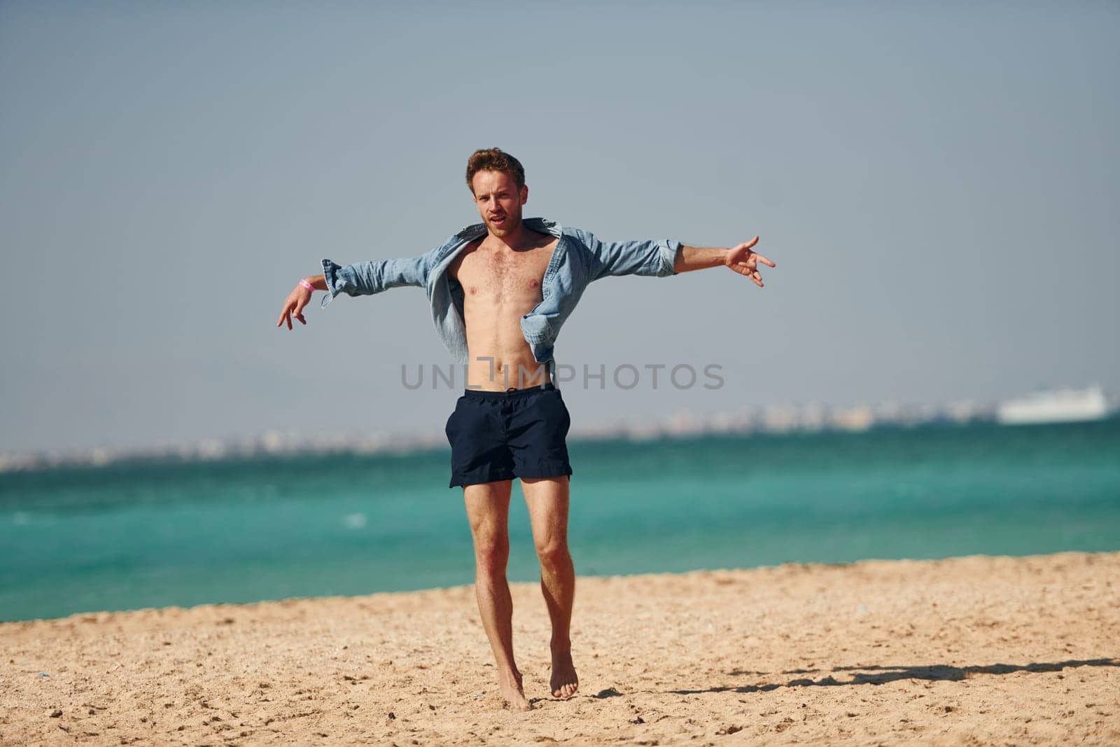 Having fun. Young european man have vacation and enjoying free time on the beach of sea.