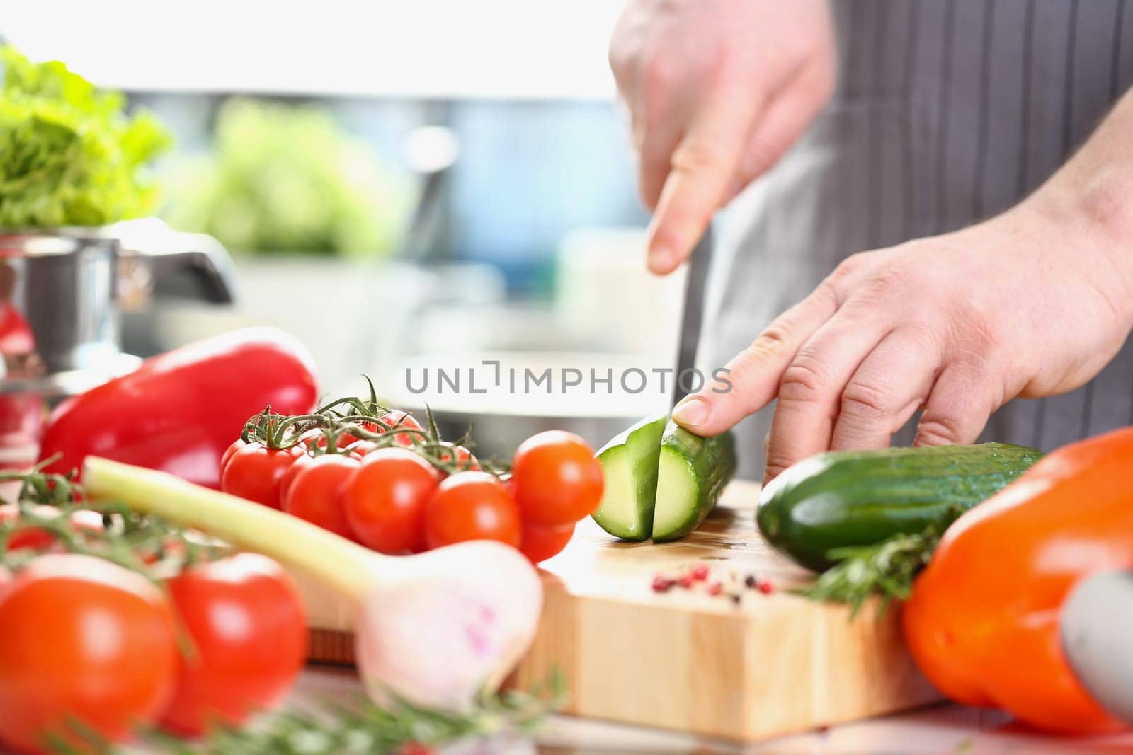 Male chef preparing healthy vegetable salad with fresh organic ingredients by kuprevich