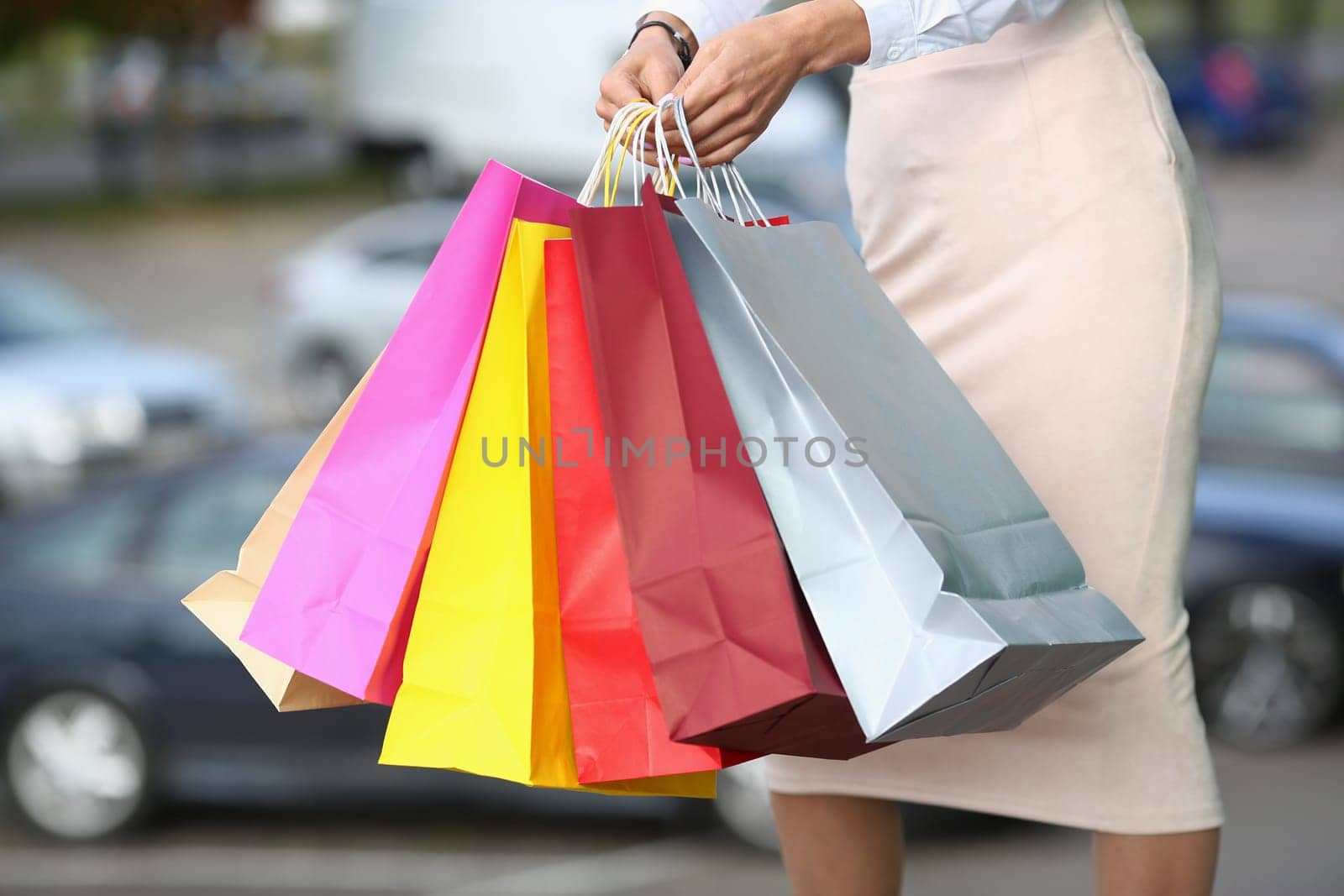 Women hands hold multicolored shopping bags. Sale and shopping concept