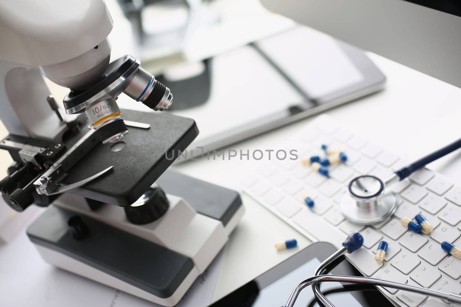 Tablets stethoscope and microscope with keyboard in laboratory. Drug development and pharmaceutical biotechnology concept