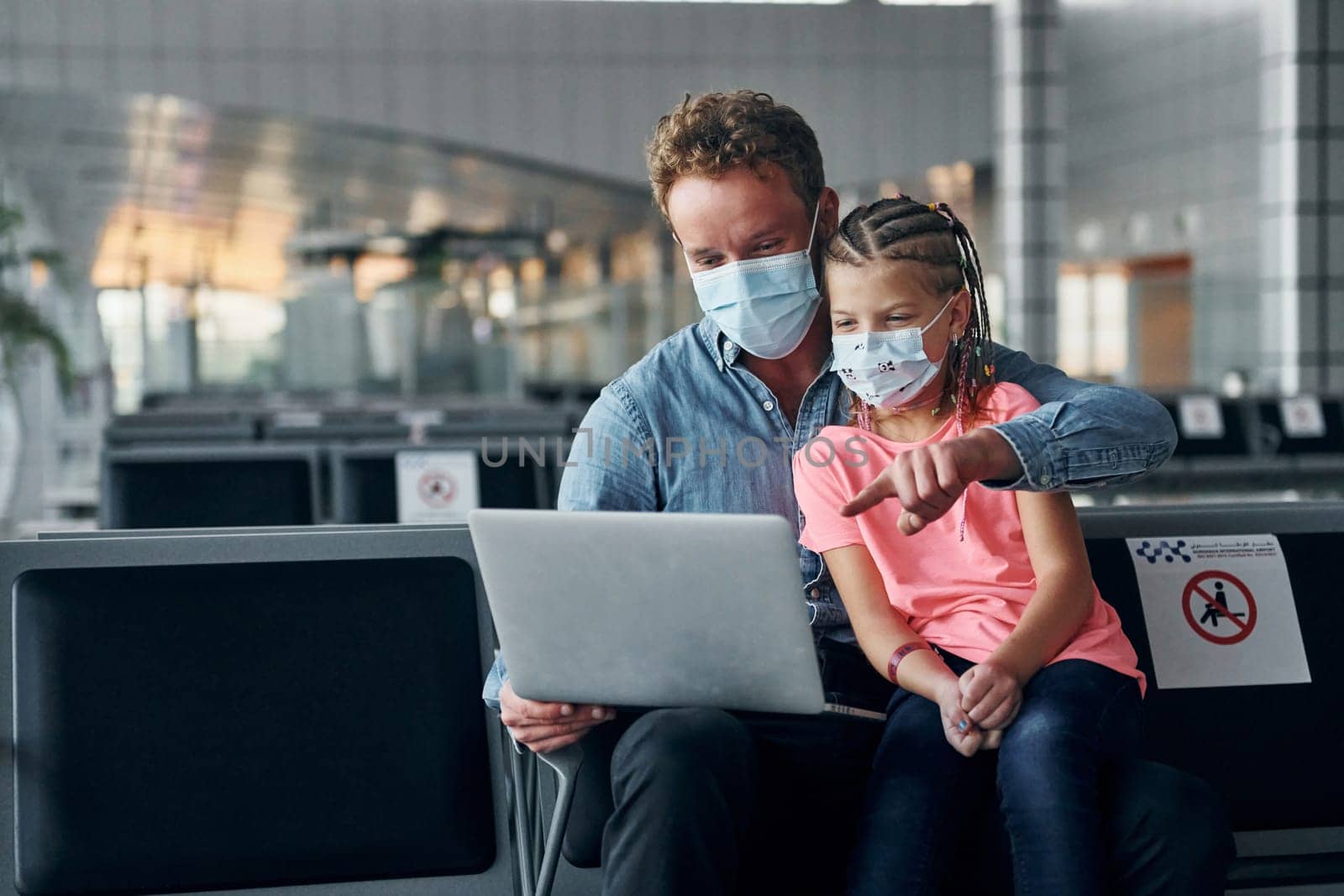 With little girl. Young man in formal wear is in modern airport.