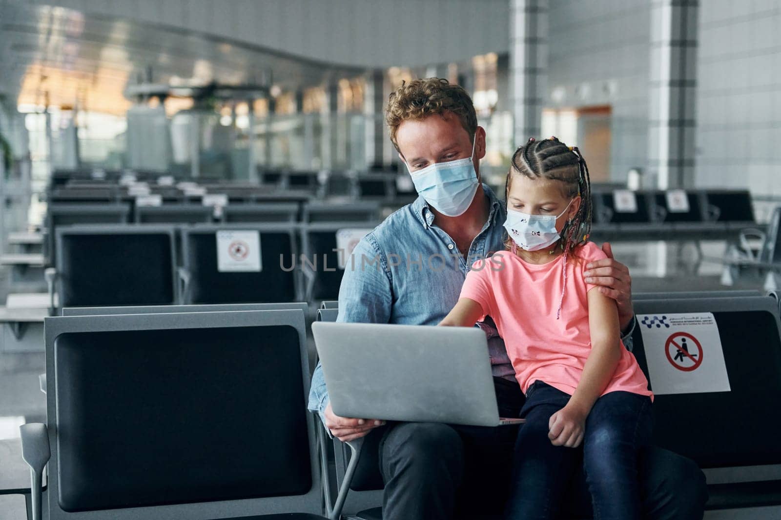 With little girl. Young man in formal wear is in modern airport.