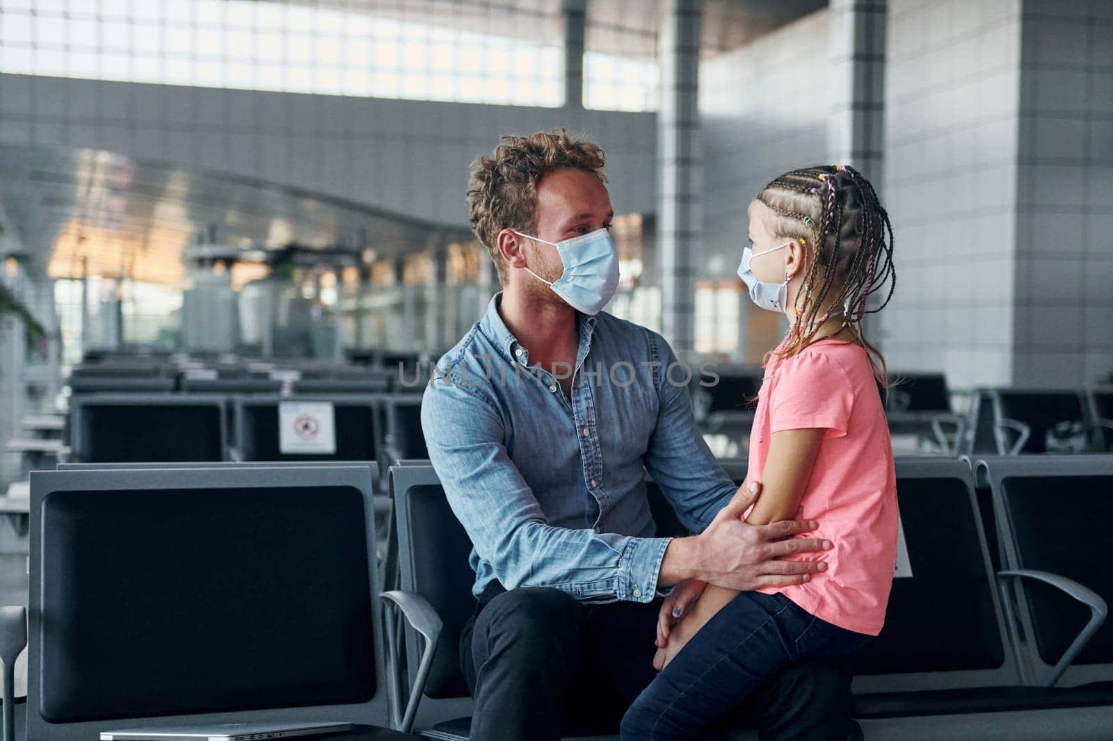 With little girl. Young man in formal wear is in modern airport.