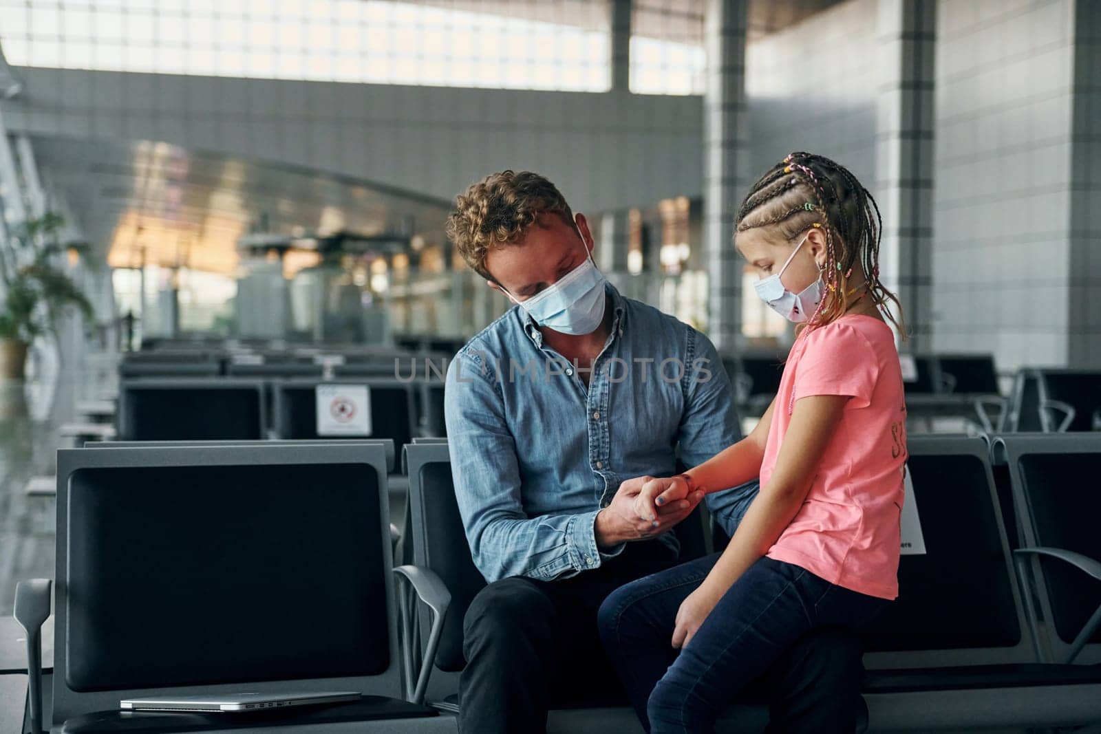 With little girl. Young man in formal wear is in modern airport.