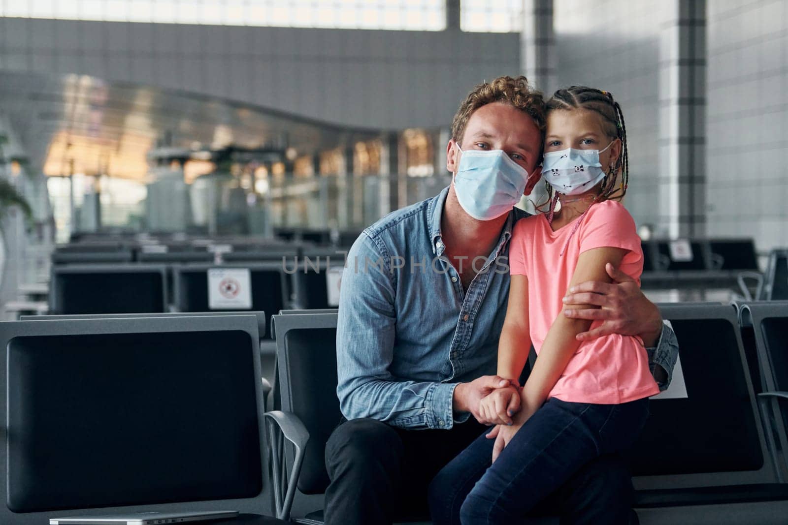 With little girl. Young man in formal wear is in modern airport.