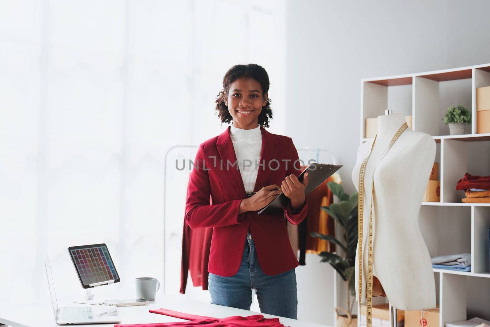 American African Fashion designer working in studio with laptop computer.