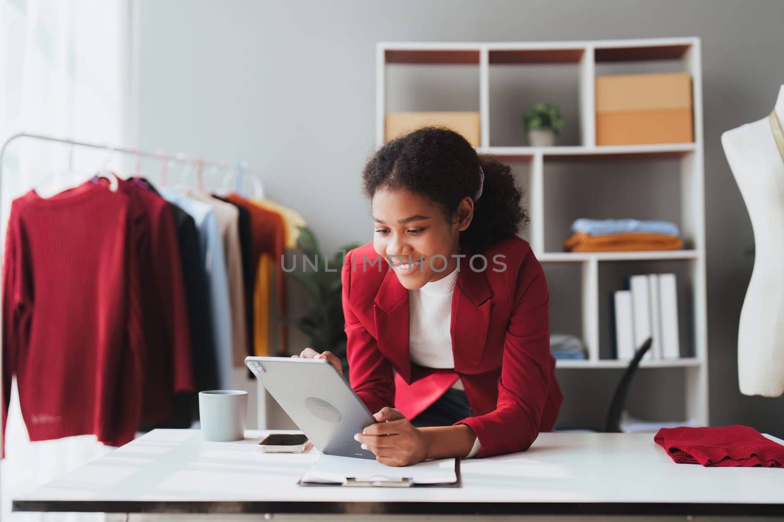 American African Fashion designer working in studio with laptop computer.