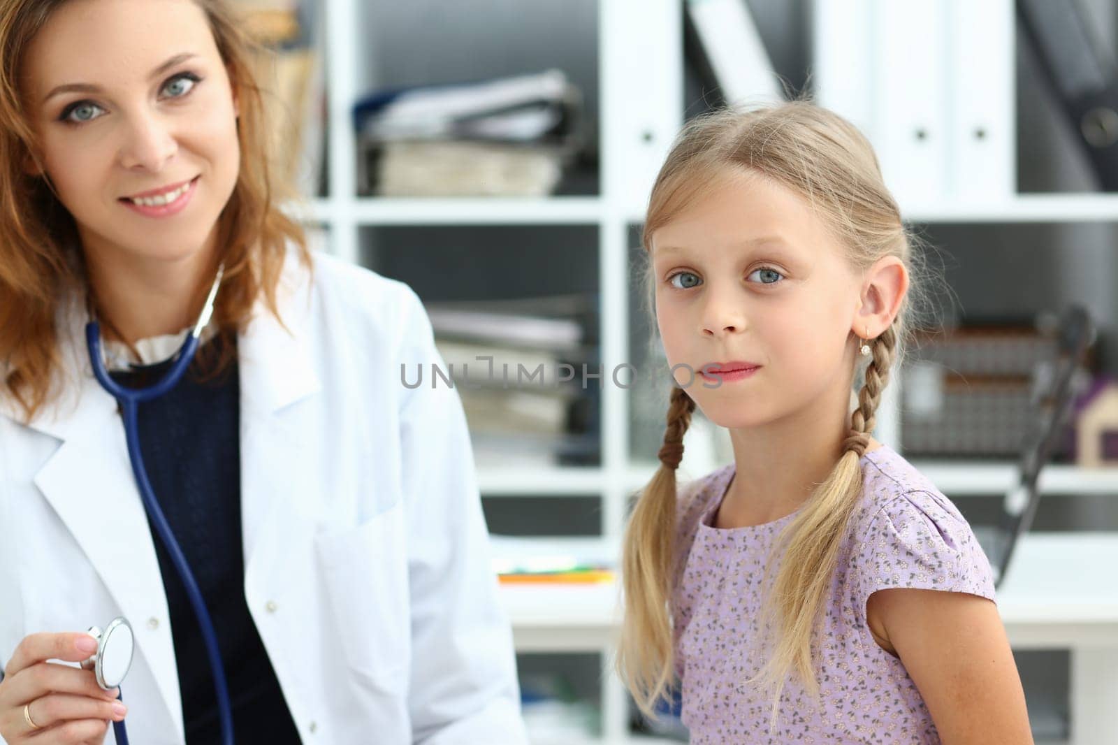 Friendly female pediatrician little girl health in clinic by kuprevich