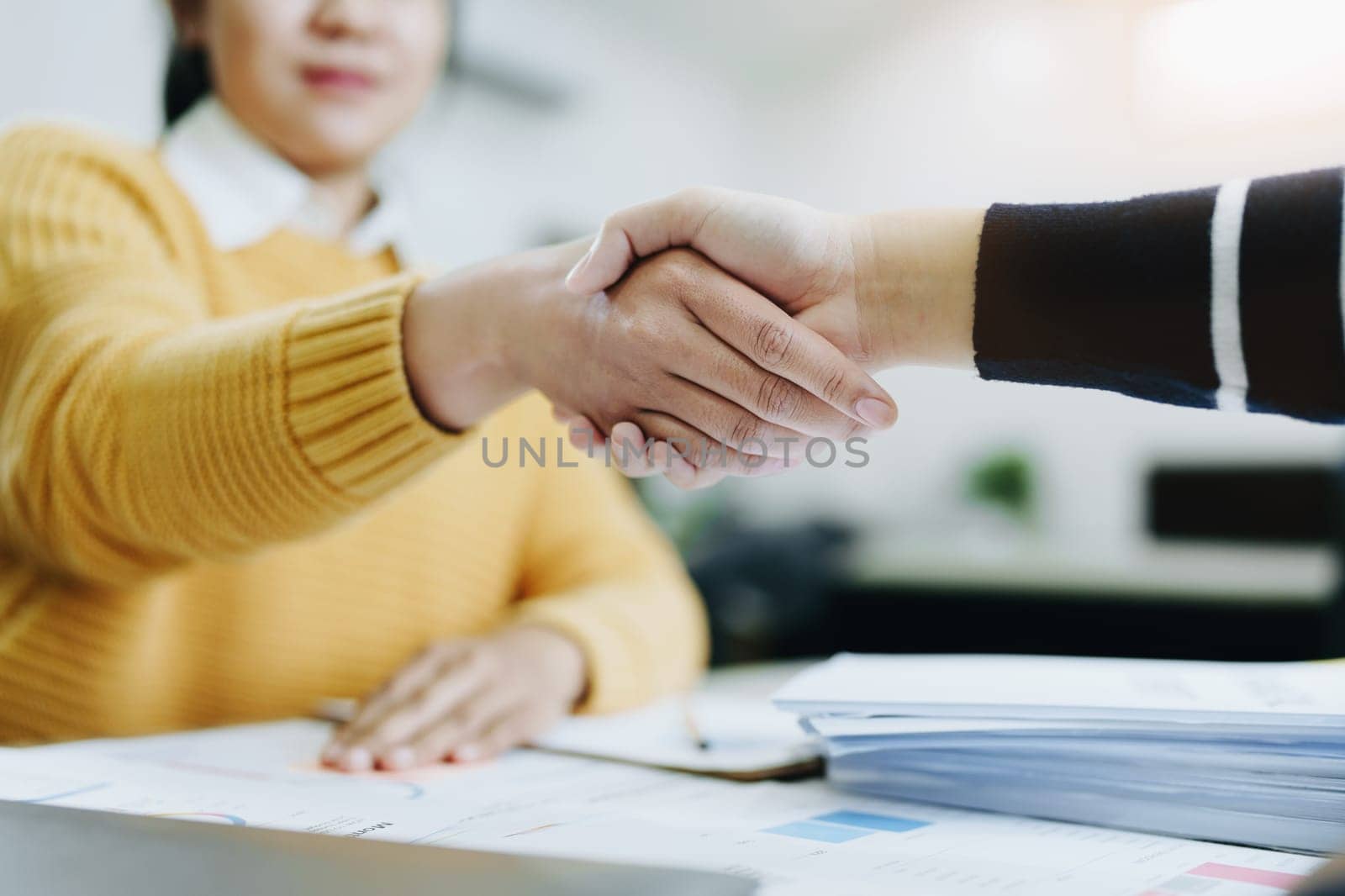 Asian entrepreneurs handshakes to congratulate the agreement between the two companies to enhance investment and financial strength. deal concept by Manastrong