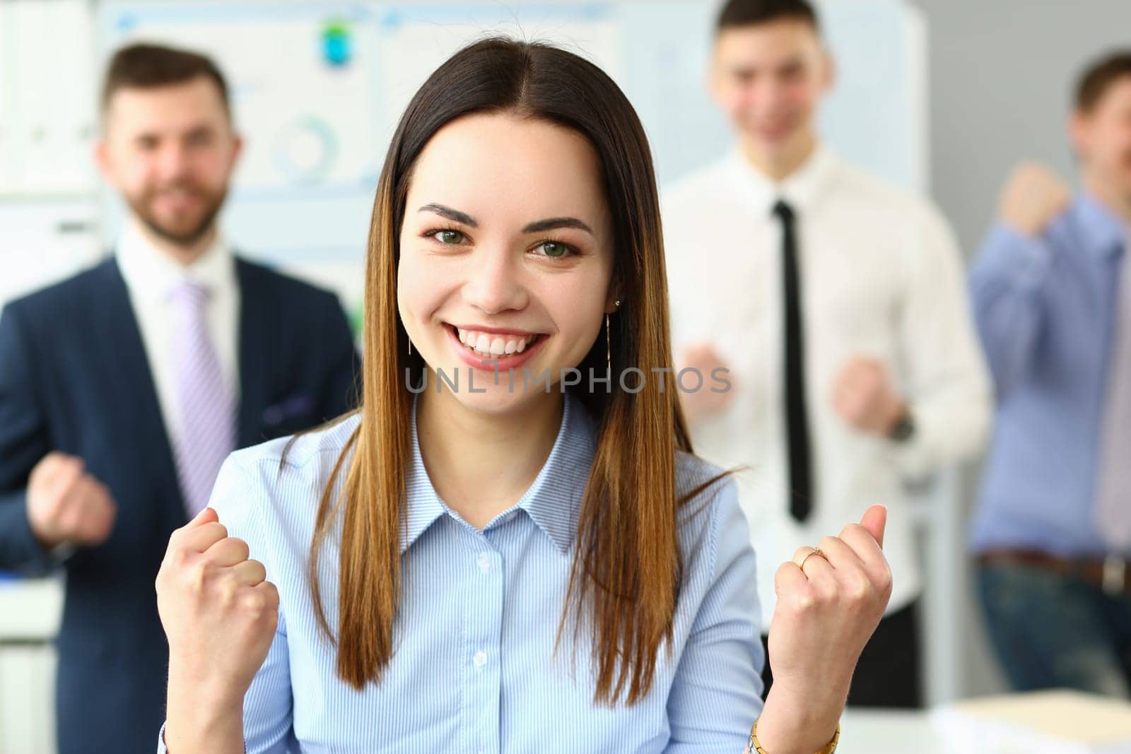 Portrait of smiling successful businesswoman and team by kuprevich