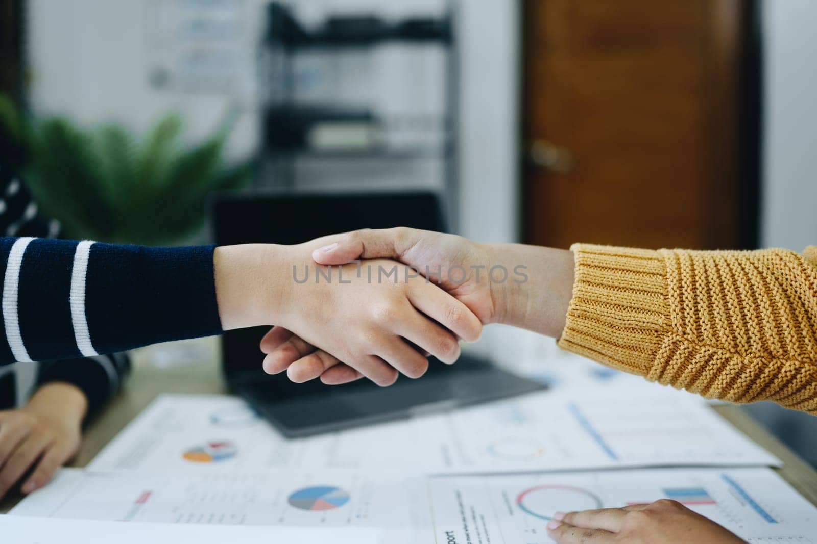 Asian entrepreneurs handshakes to congratulate the agreement between the two companies to enhance investment and financial strength. deal concept by Manastrong