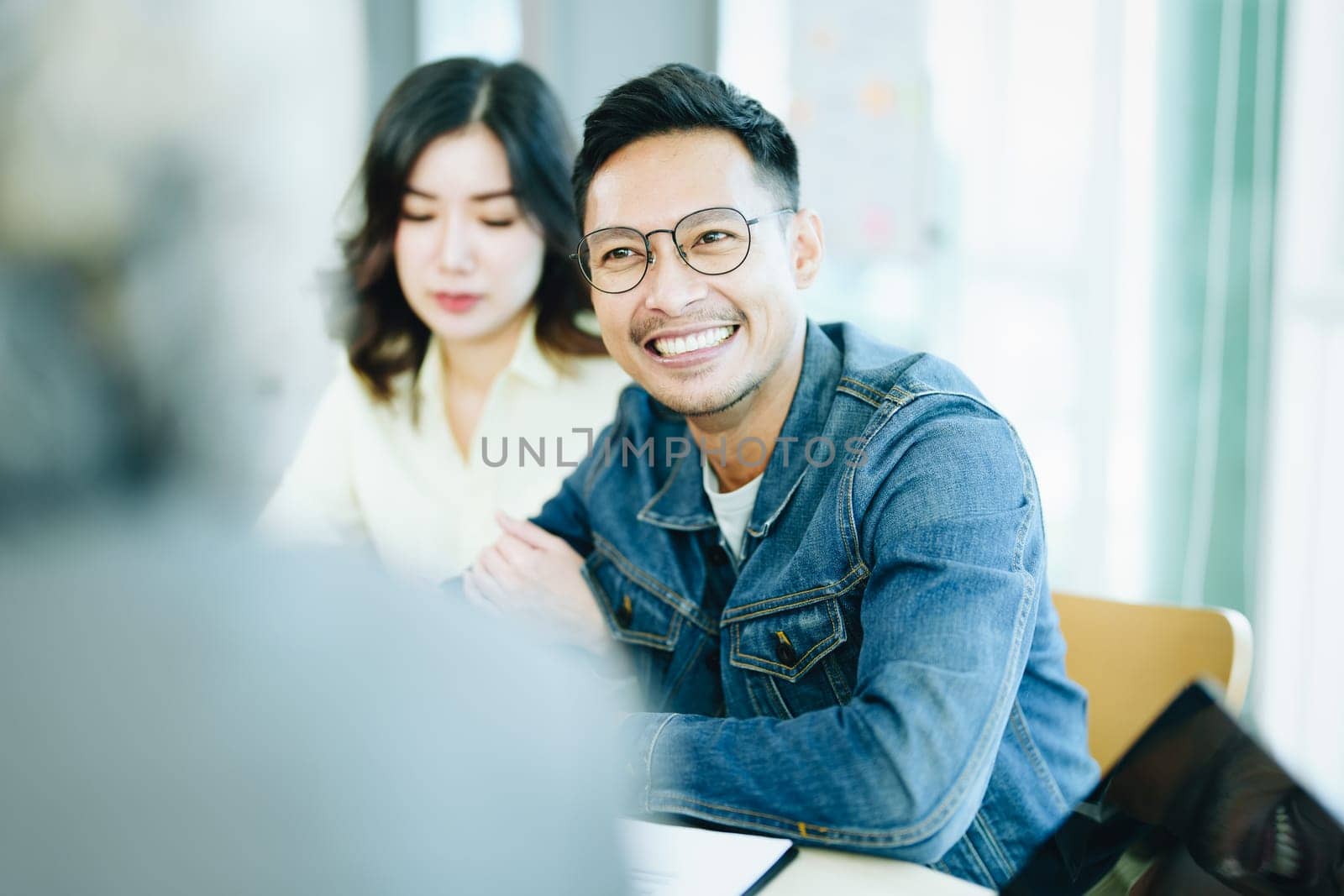 Guarantee Insurance Sign a contract, couple a smiling couple is signing a contract to invest in real estate with the Mortgage officer with the bank by Manastrong