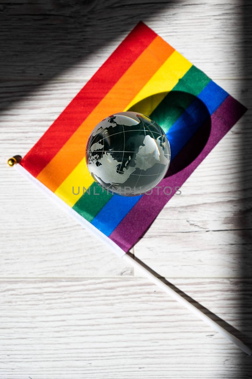 Crystal globe on a rainbow flag. LGBT community. by mrwed54