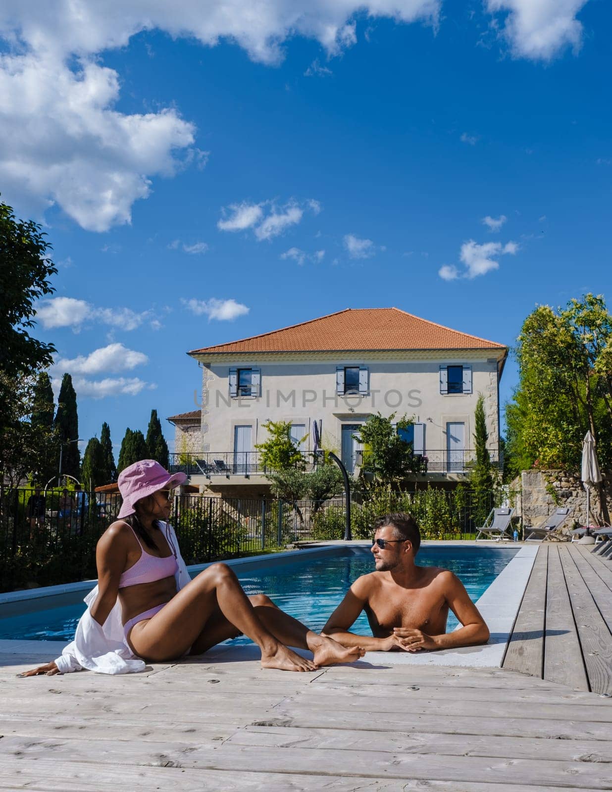 couple men and women in swimming pool of luxury vacation home in the Ardeche France Europe by fokkebok