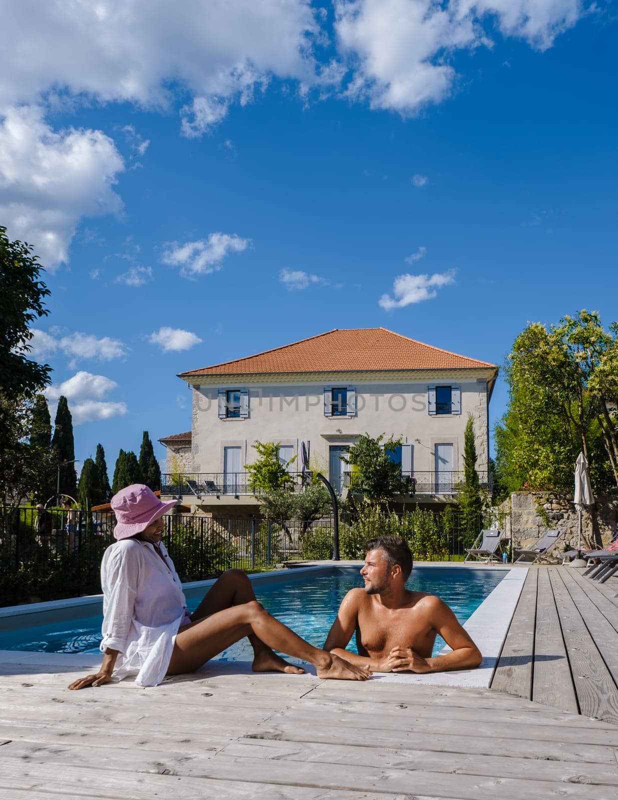 couple men and women in swimming pool of luxury vacation home in the Ardeche France Europe by fokkebok