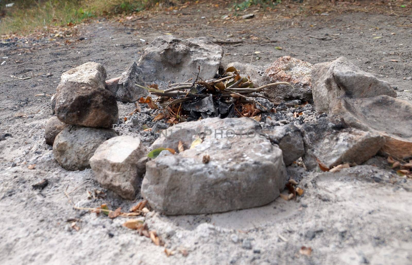 an extinct fire pit surrounded by stones by Annado