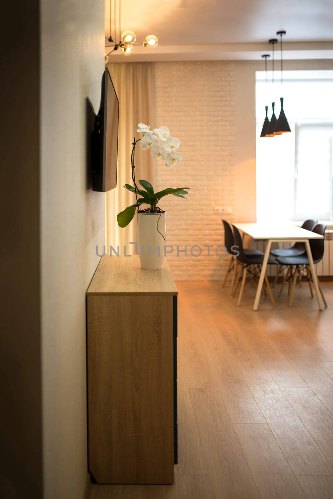 Open plan living room and kitchen interior with white cabinets, table and chairs by aprilphoto