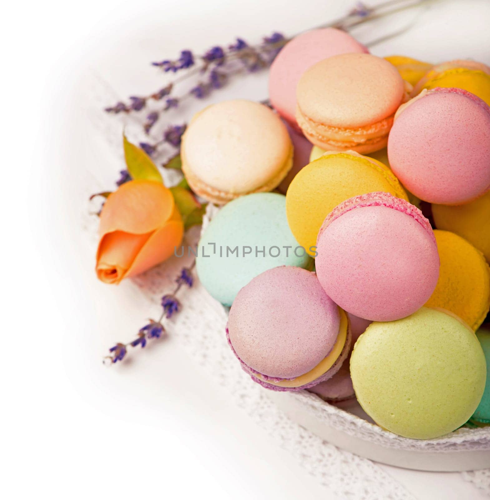 Many delicious colorful macarons in box on white background by aprilphoto