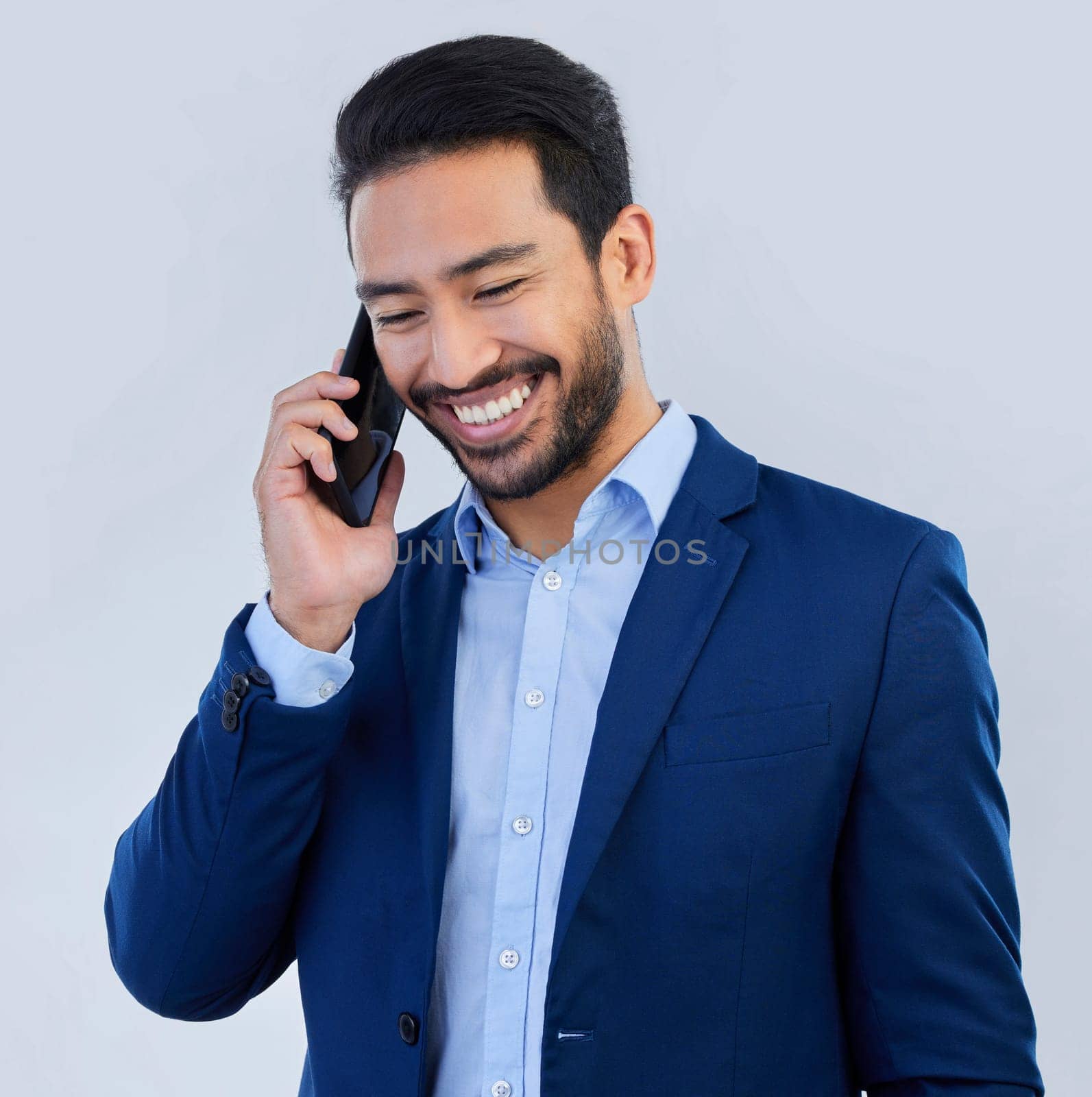 Smile, phone call and asian businessman in studio, talking and networking on white background. Smartphone, conversation and man in suit, communication and technology for investor trading at startup. by YuriArcurs