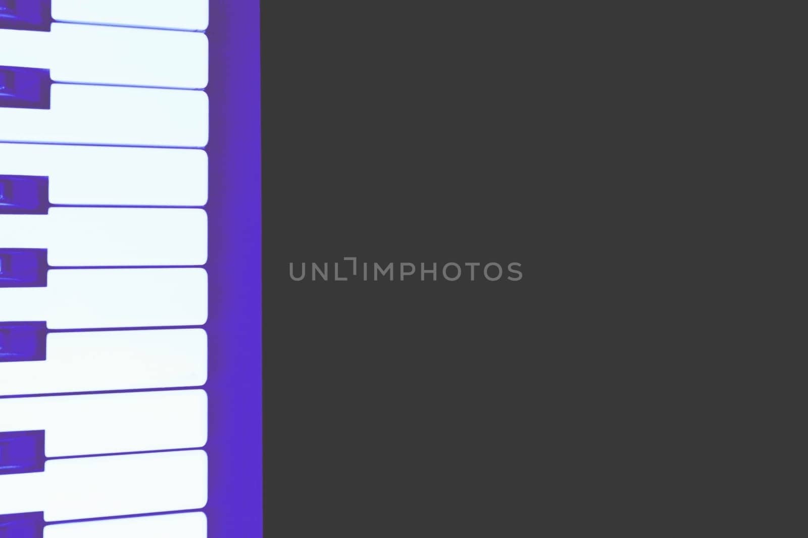 Purple musical synthesizer piano keys on a black surface for text, advertising by jovani68