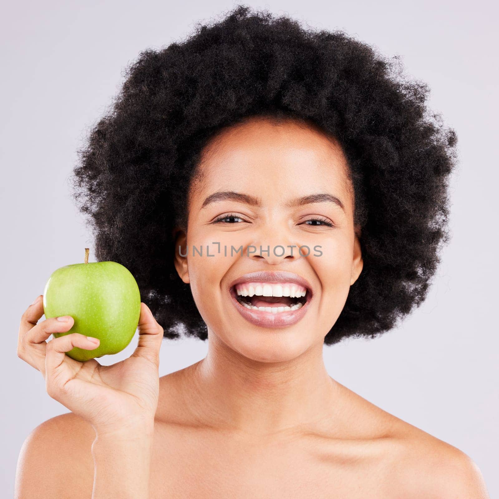 Portrait, health and black woman with apple, diet and happiness against a grey studio background. Face, African American female and lady with fruit, wellness and healthy lifestyle with smile and joy by YuriArcurs