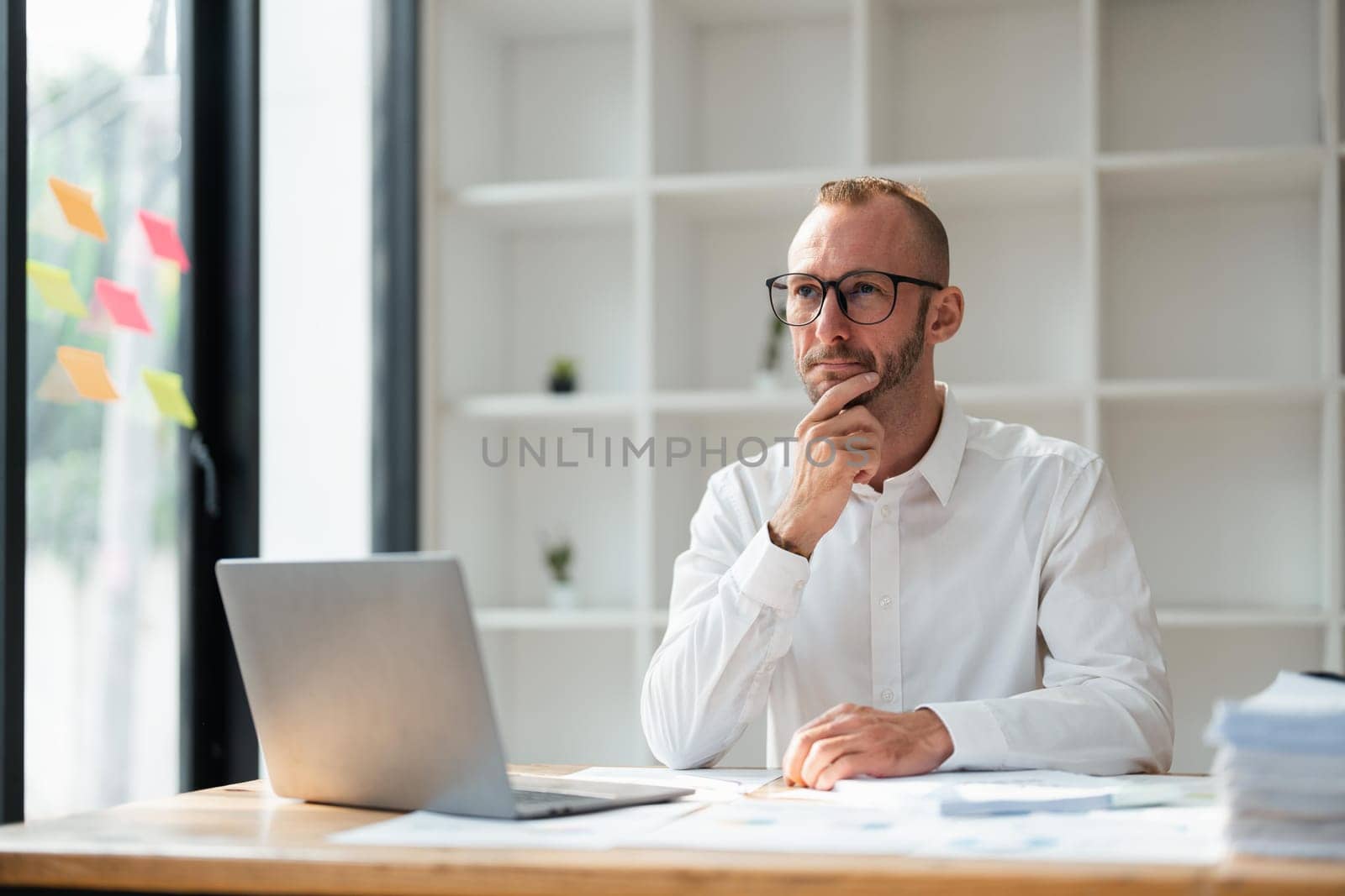 Image of young businessman analyzing work using a laptop at office by nateemee