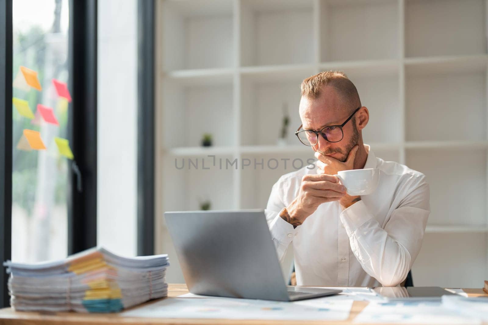businessman using laptop and drinking coffee at office.