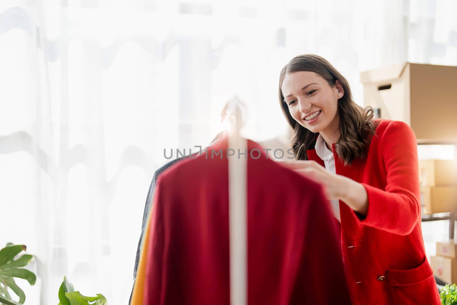 young woman work for checking the clothes in the home, concept e commerce. by wichayada