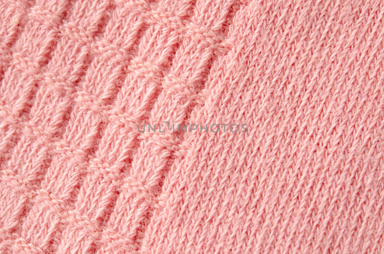 Texture of a knitted woolen pink color cloth. Background.