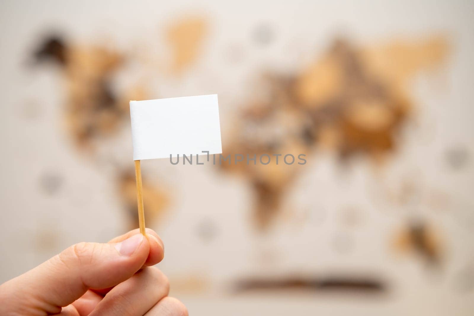 White flag with copy space in man hands with world map on the background.