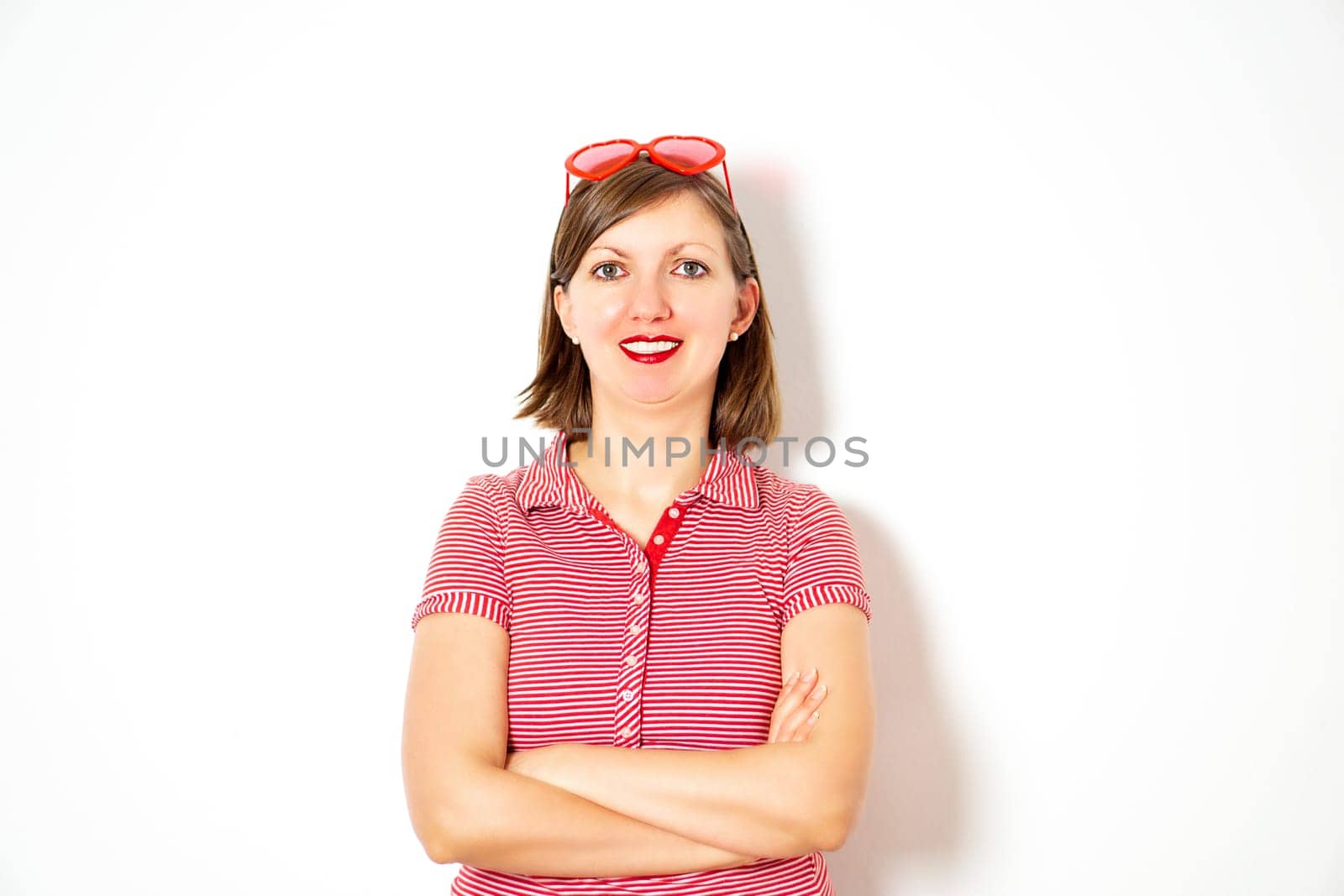 Portrait of the young smiling attractive woman with red heart sunglasses on the white background. by tanjas_photoarts