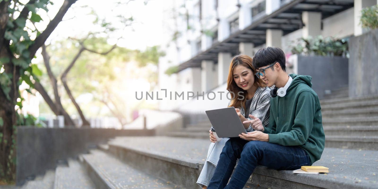 Group of Asian college student reading books and tutoring special class for exam on grass field at outdoors. Happiness and Education learning concept. Back to school concept. Teen and people theme...