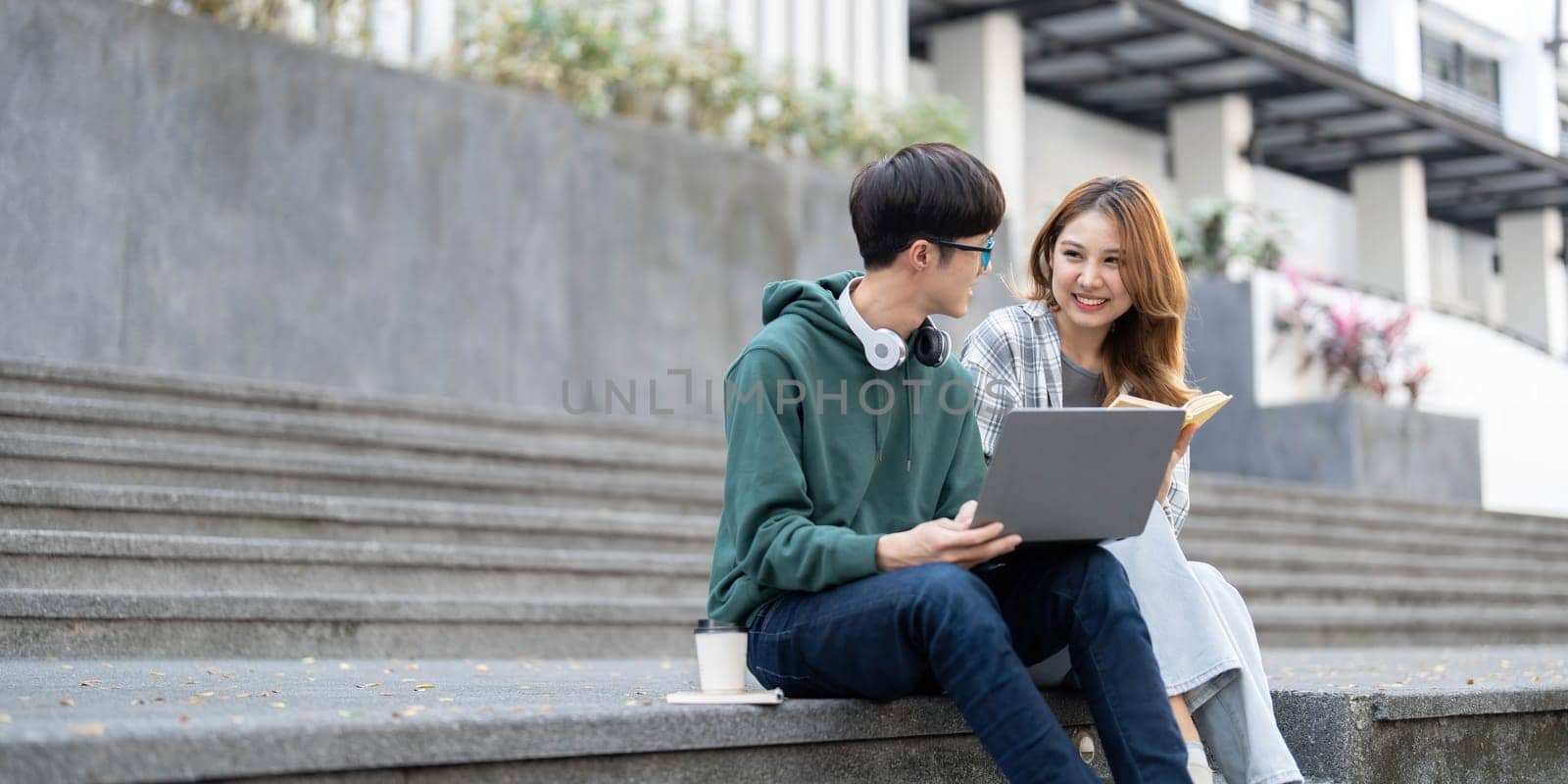 Group of Asian college student reading books and tutoring special class for exam on grass field at outdoors. Happiness and Education learning concept. Back to school concept. Teen and people theme...