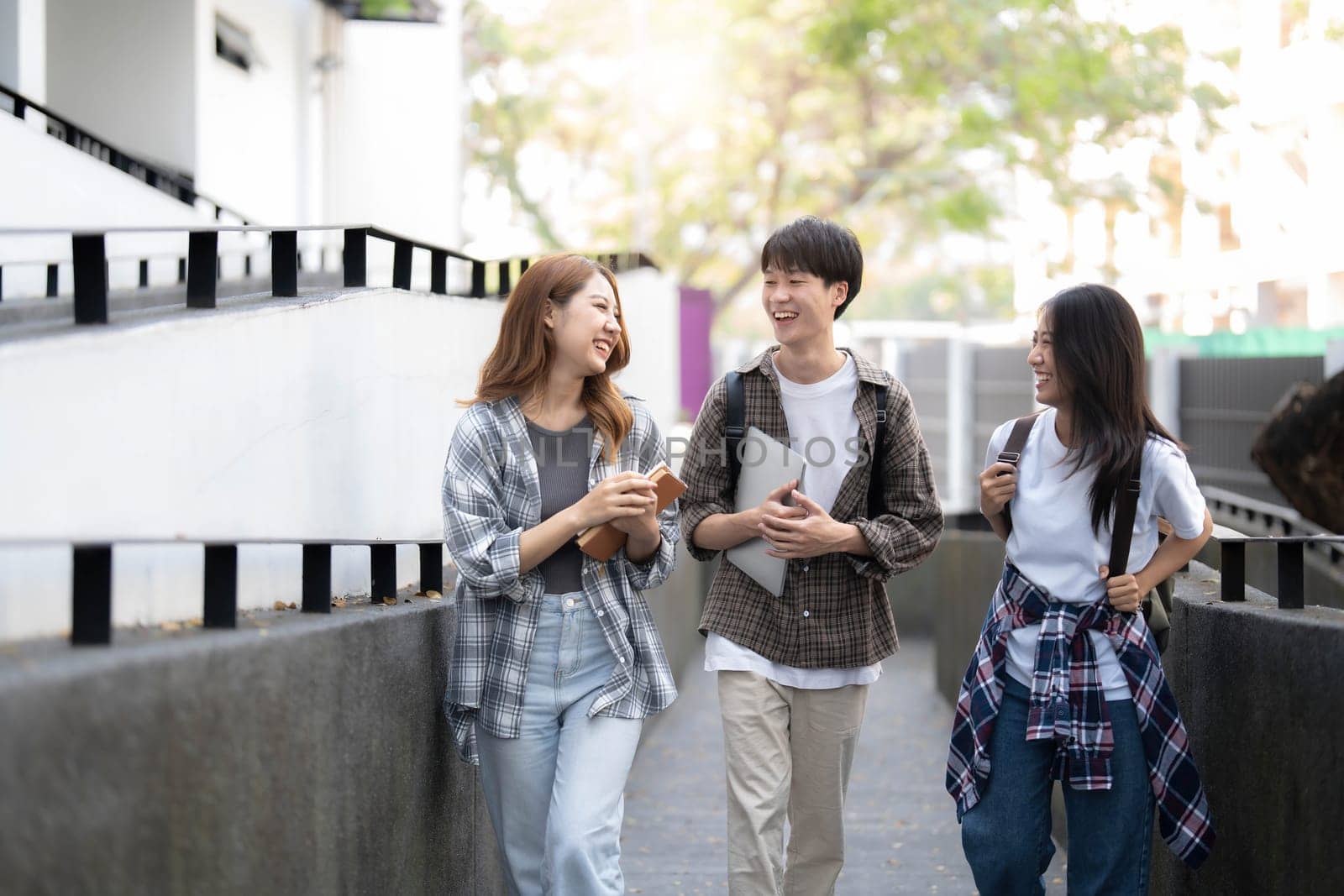 Group of Asian college student reading books and tutoring special class for exam on grass field at outdoors. Happiness and Education learning concept. Back to school concept. Teen and people theme...