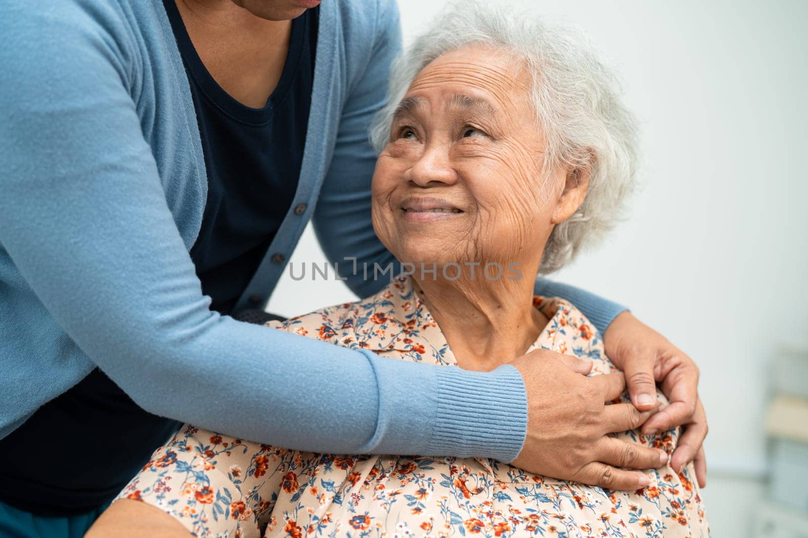 Caregiver help Asian elderly woman patient with love, care, encourage and empathy at nursing hospital, healthy strong medical concept.