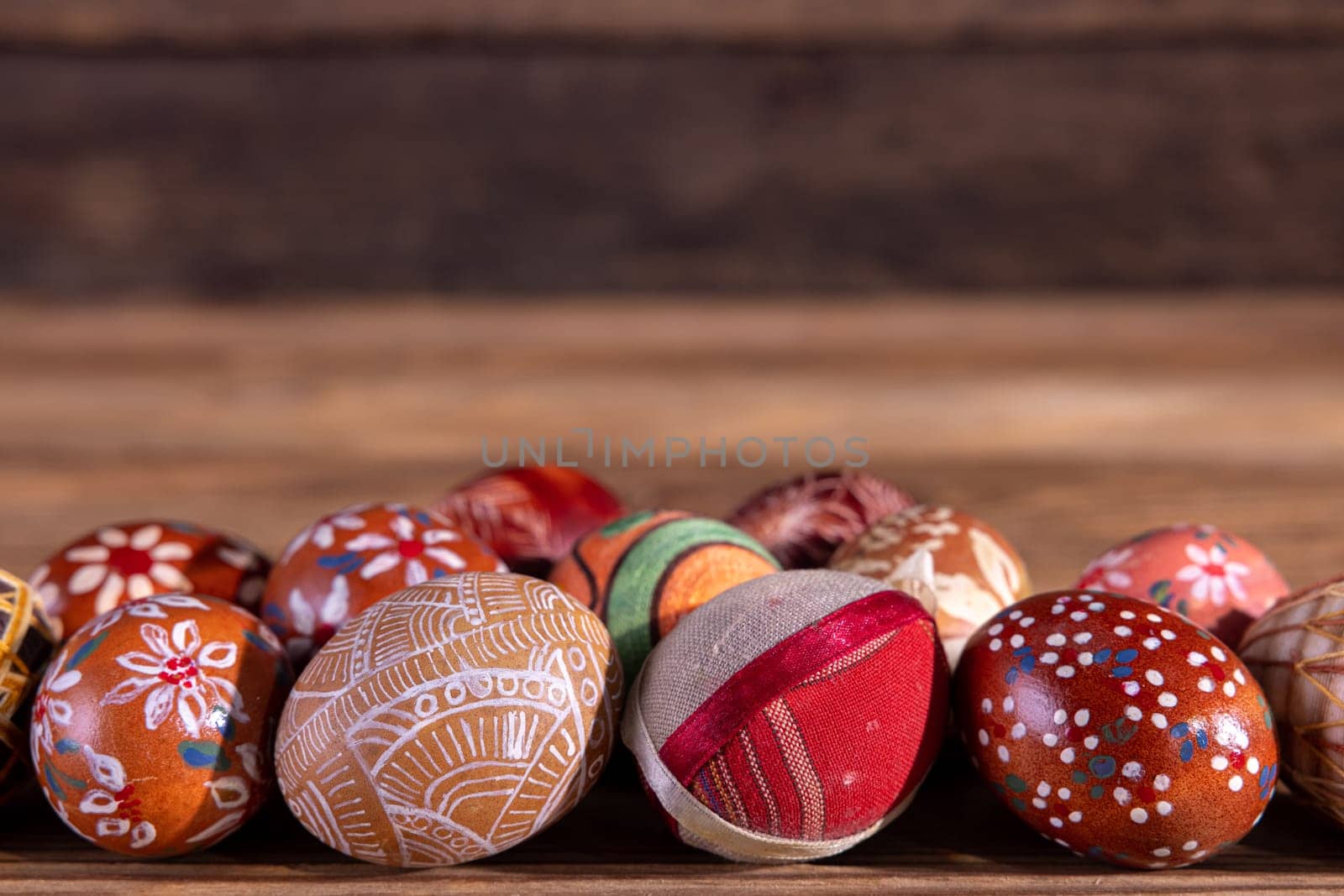 A close-up view of the Easter eggs arranged in a single line, kept in the brown color scheme with space for your own artwork or Easter inscription.