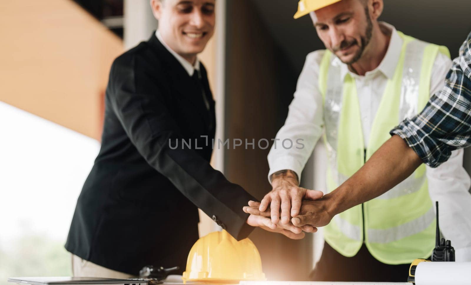 Civil engineer teams meeting working together wear worker helmets hardhat on construction site in modern city. Foreman industry project manager engineer teamwork. Asian industry professional team..