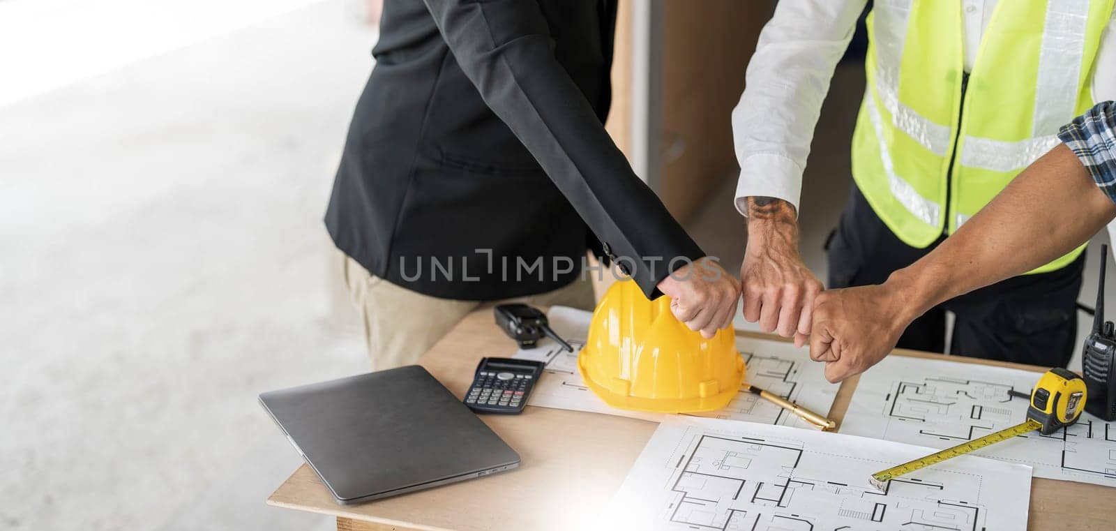 Civil engineer teams meeting working together wear worker helmets hardhat on construction site in modern city. Foreman industry project manager engineer teamwork. Asian industry professional team by wichayada