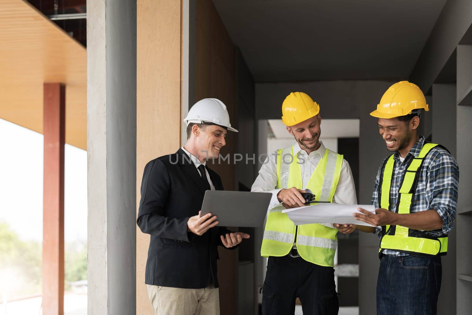 Civil engineer teams meeting working together wear worker helmets hardhat on construction site in modern city. Foreman industry project manager engineer teamwork. Asian industry professional team. by wichayada