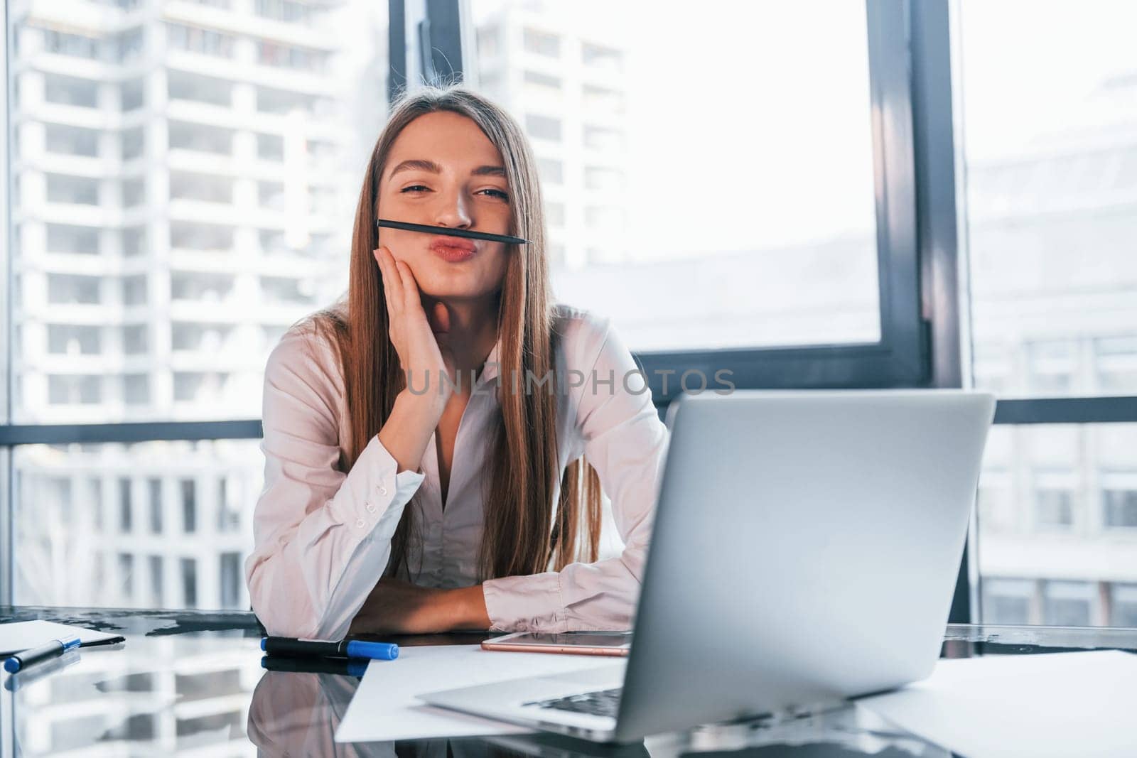 Have fun at break. Young woman in white formal clothes is indoors in the modern office.