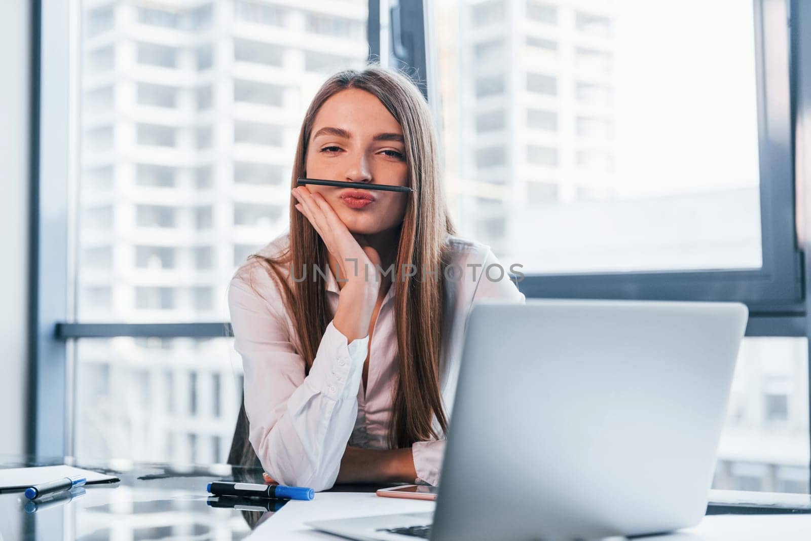 Have fun at break. Young woman in white formal clothes is indoors in the modern office.
